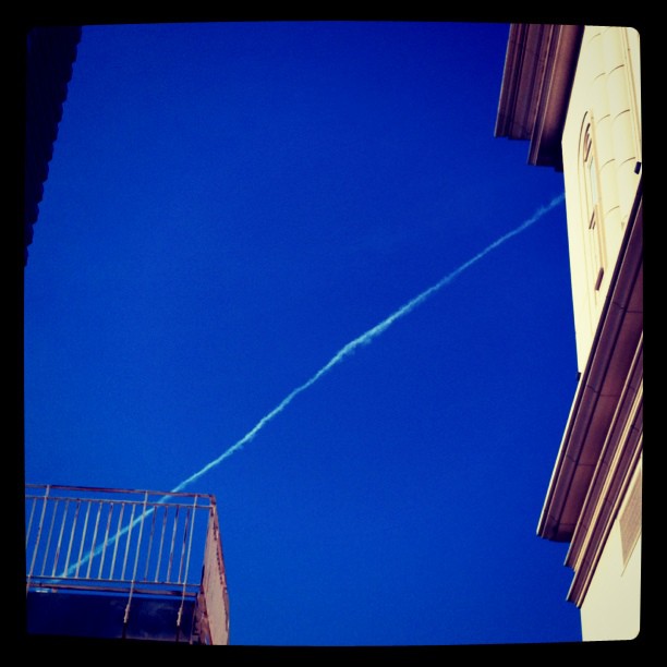 ビル間の飛行機雲