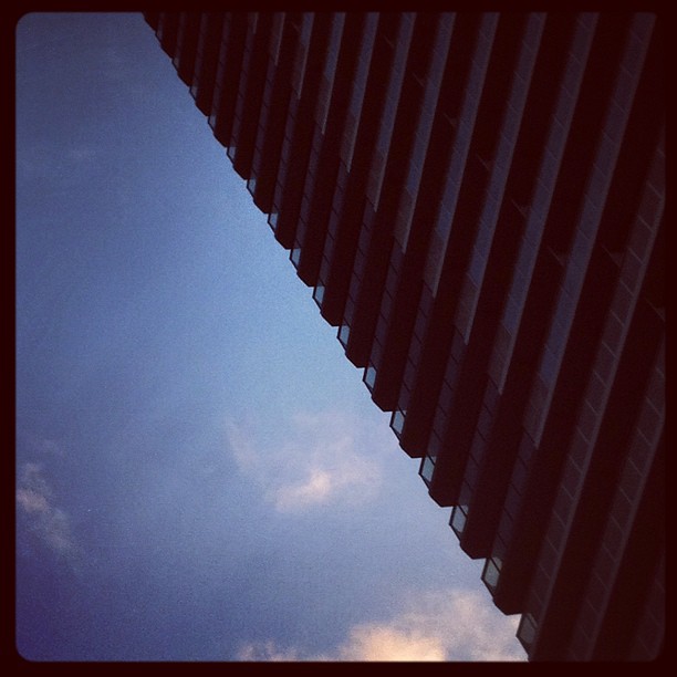 高層マンション外壁と空との境界が、開いたファスナーのよう